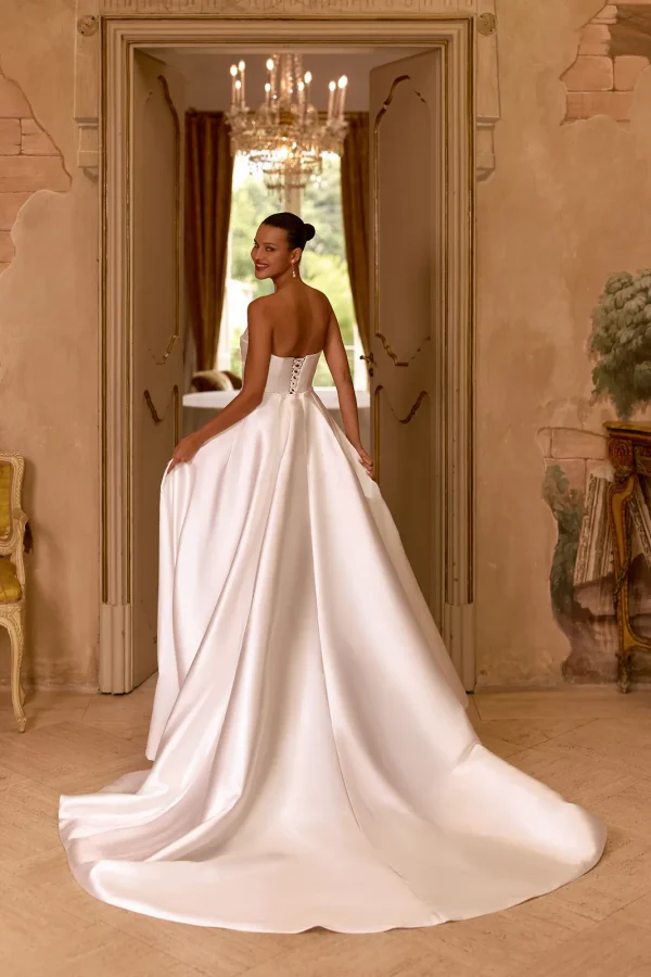 Dos nu et longue surjupe d'une robe de mariée courte en satin bustier