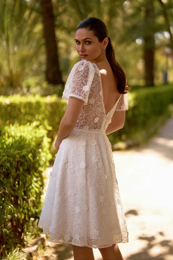 Dos nu en V d'une robe de mariée courte en dentelle florale à manches courtes