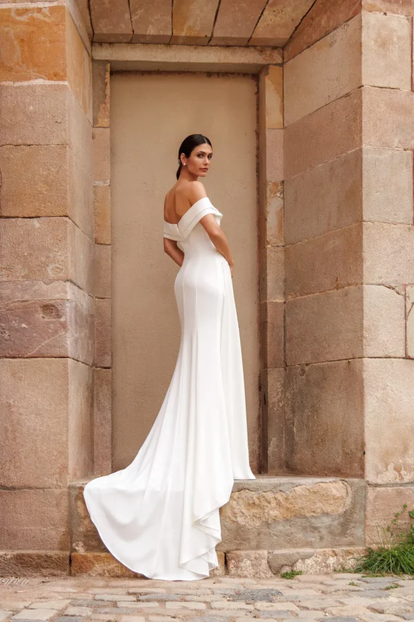 Épaules dénudées et traîne d'une robe de mariée droite en crêpe à col Bardot