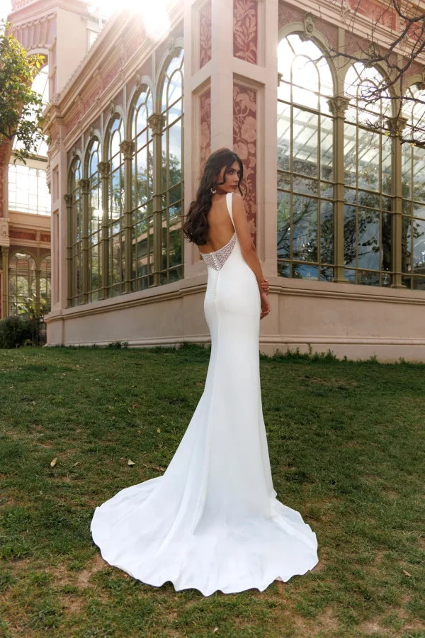 Dos nu bordé de dentelle et traîne d'une robe de mariée droite en crêpe