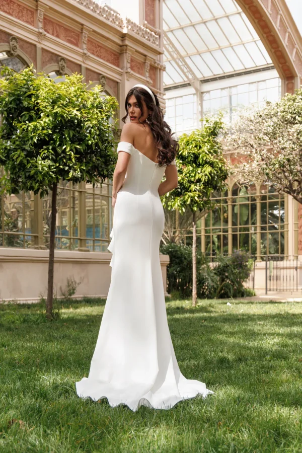 Dos et traîne d'une robe de mariée droite en crêpe à col Bardot