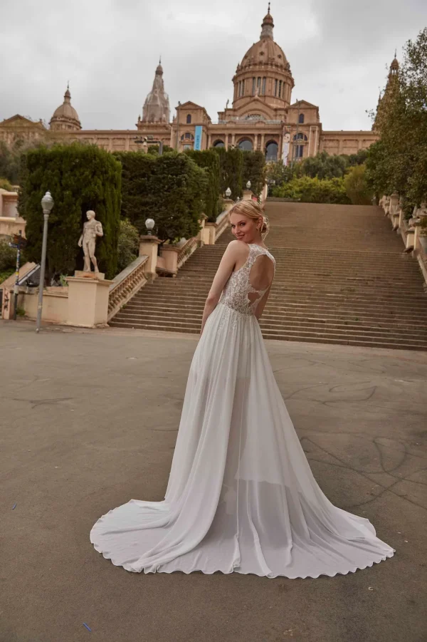 Dos ajouré et traîne en mousseline d'une robe de mariée droite à corsage en dentelle