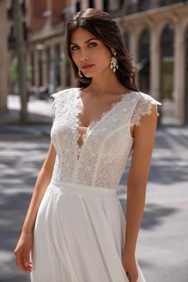 Corsage en guipure à col en V et mancherons d'une robe de mariée droite en mousseline