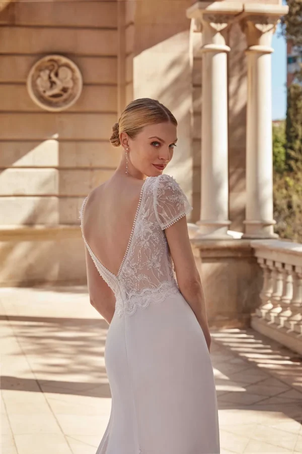 Dos nu en V boutonné en dentelle d'une robe de mariée droite en mousseline