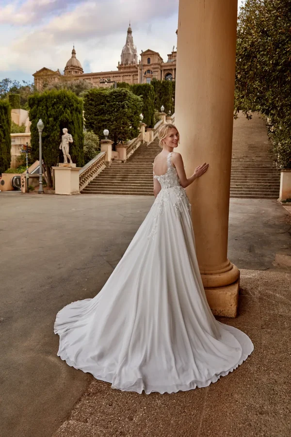 Dos décolleté et longue traîne d'une robe de mariée droite en mousseline à fleurs 3D