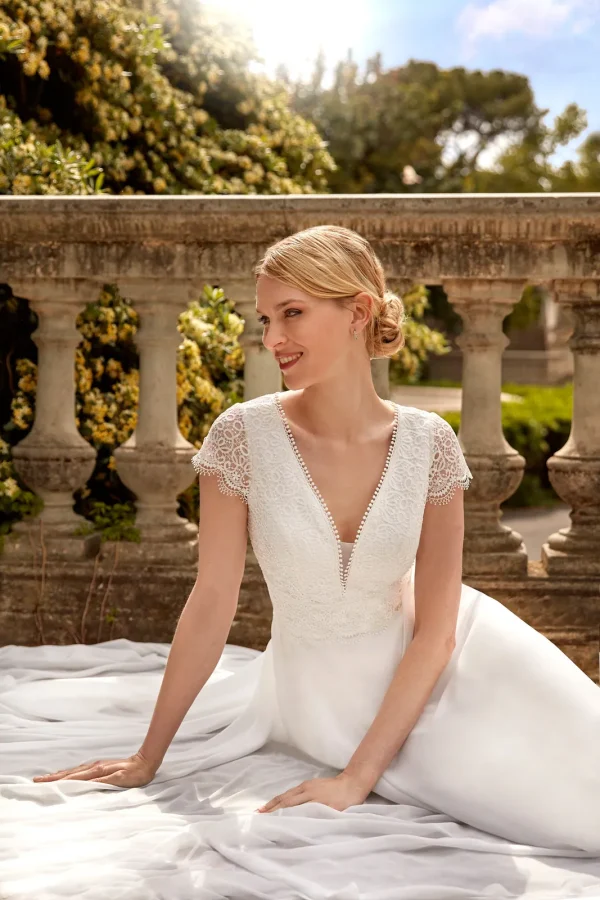 Col en V bordé de perles et corsage en dentelle d'une robe de mariée droite en mousseline