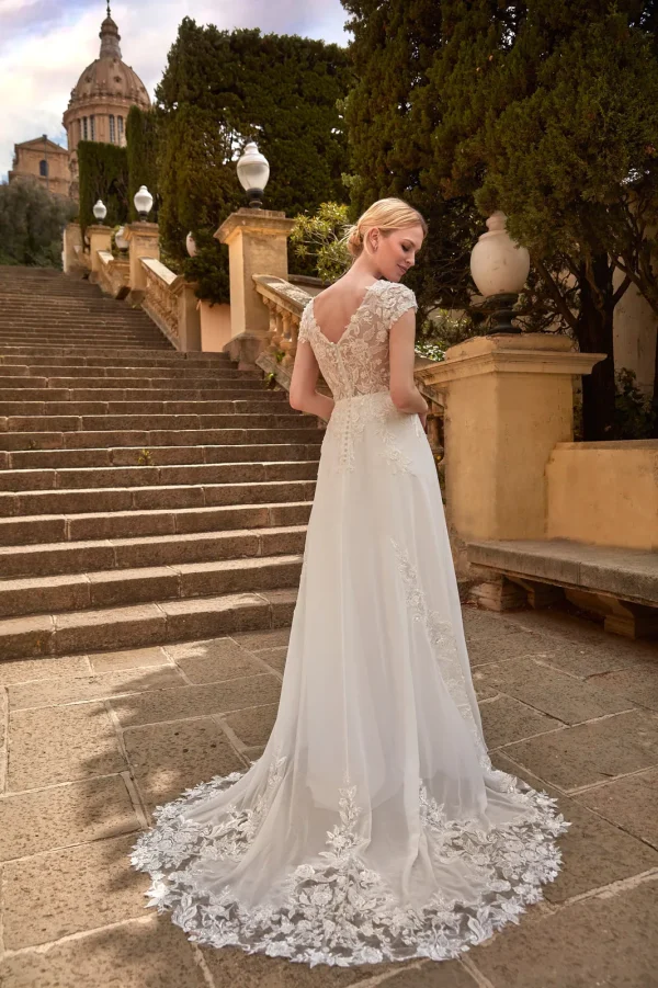 Dos en V boutonné et traîne en dentelle d'une robe de mariée droite en mousseline