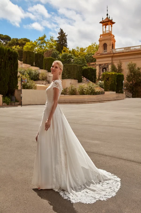 Longue traîne bordée de dentelle d'une robe de mariée droite en mousseline