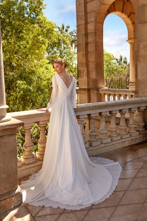 Dos en V et longue traîne d'une robe de mariée droite à manches bouffantes