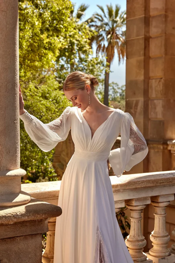 Manches bouffantes brodées et col en V drapé d'une robe de mariée droite en mousseline