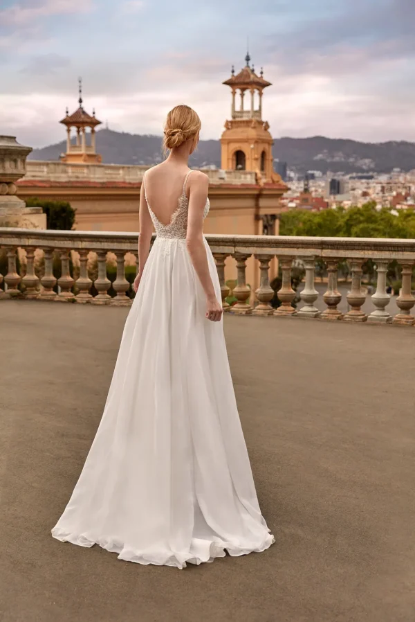 Dos nu en V et jupe fluide d'une robe de mariée droite en mousseline à fines bretelles