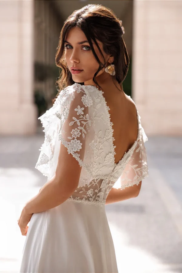 Dos nu en V et manches papillon en dentelle d'une robe de mariée droite