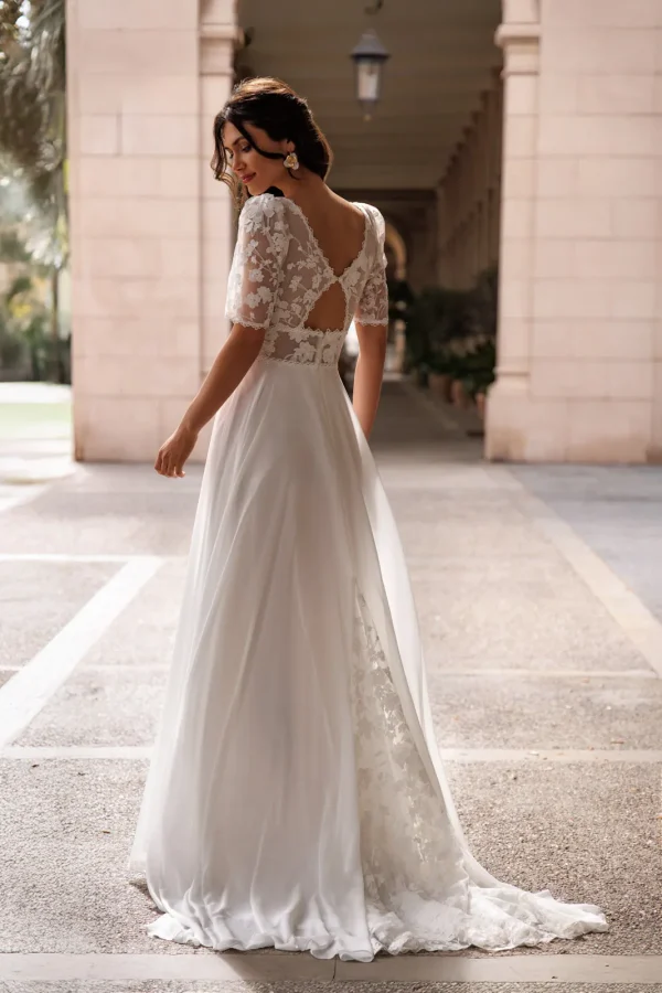 Dos ajouré à manches en dentelle et traîne d'une robe de mariée droite en mousseline