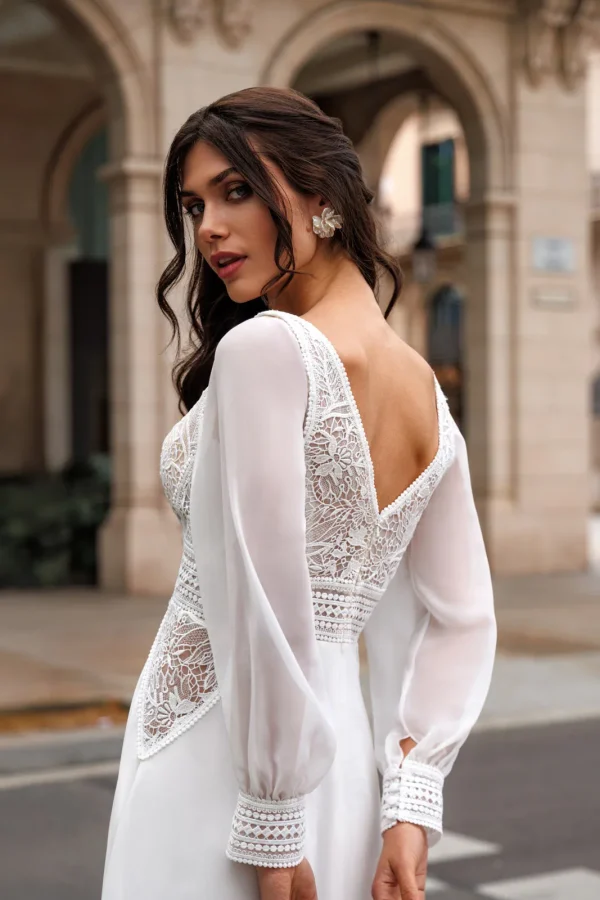 Dos en V, dentelle et manches bouffantes d'une robe de mariée droite en mousseline