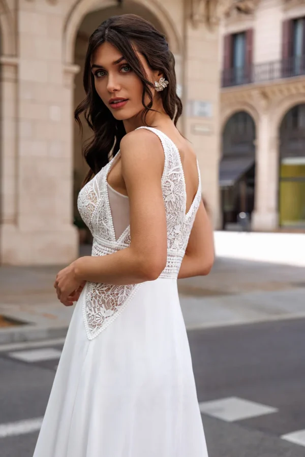 Dos en V en dentelle d'une robe de mariée droite portée sans ses manches amovibles