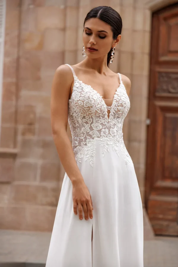 Corsage en dentelle et fines bretelles d'une robe de mariée droite en mousseline