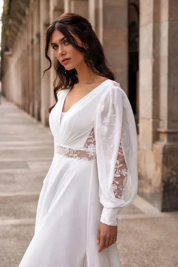 Manches bouffantes brodées et ceinture perlée d'une robe de mariée droite en mousseline