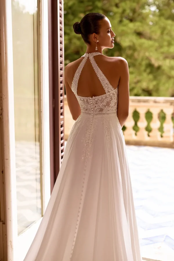 Dos ajouré à bretelles croisées et boutons d'une robe de mariée droite en mousseline