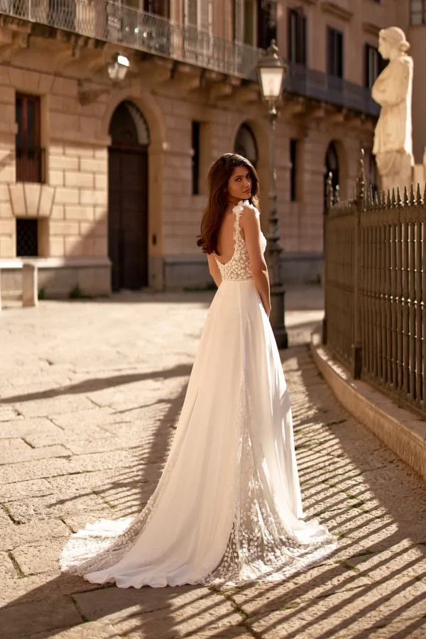 Dos nu et traîne parsemée de fleurs d'une robe de mariée droite en mousseline