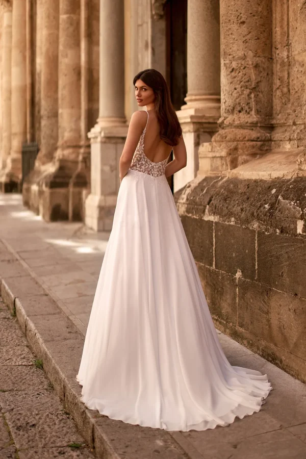 Dos nu et traîne en mousseline d'une robe de mariée droite à fines bretelles