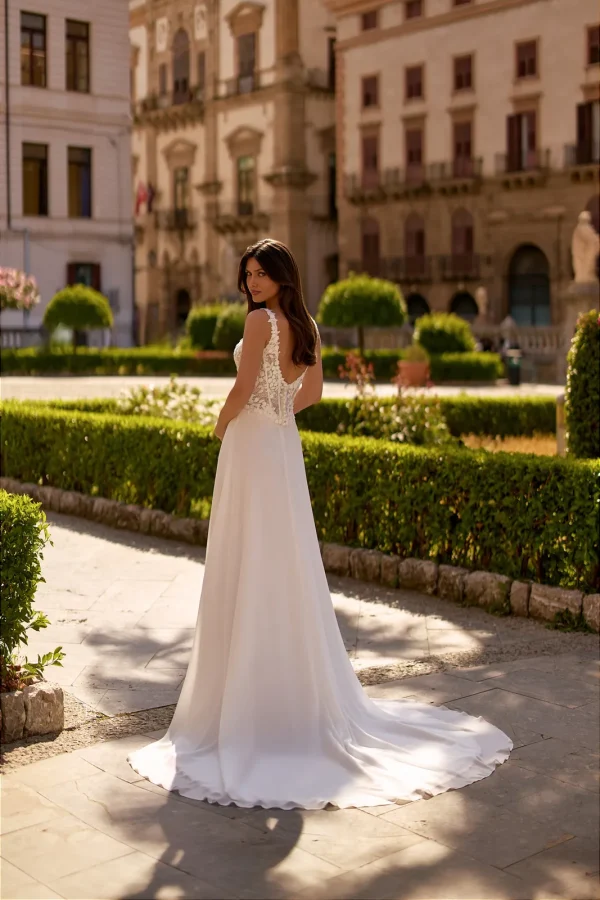 Dos nu et traîne d'une robe de mariée droite en mousseline à corsage fleuri