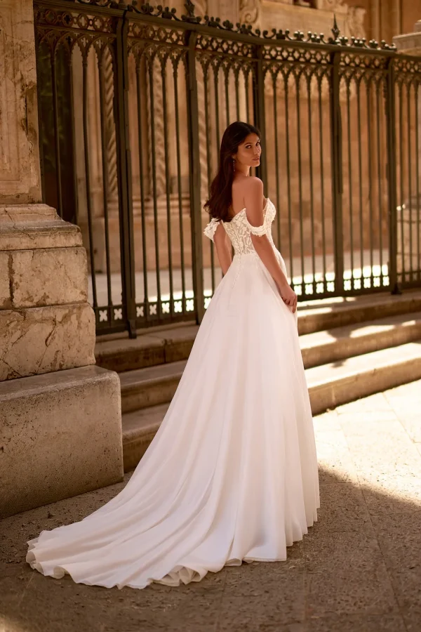 Dos et longue traîne d'une robe de mariée droite en mousseline à épaules dénudées