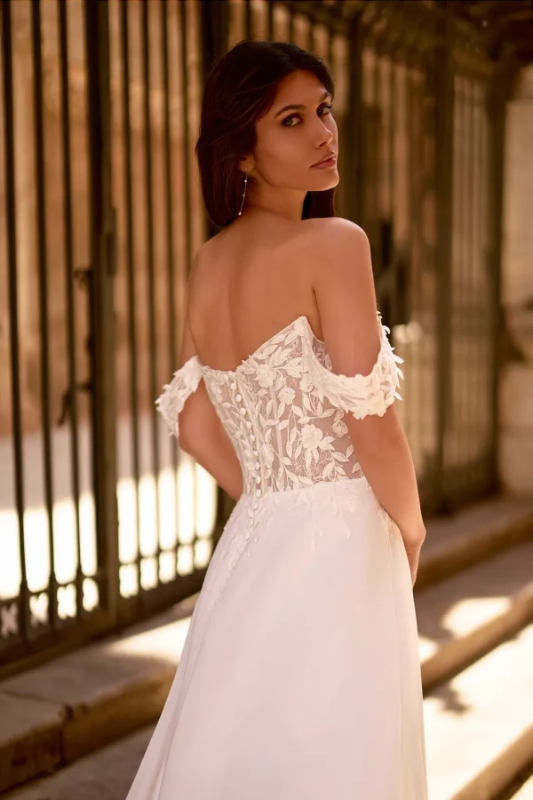 Dos corseté en dentelle et bretelles tombantes d'une robe de mariée droite