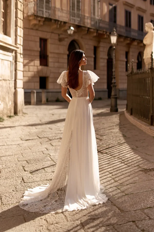 Dos et traîne en dentelle d'une robe de mariée droite en mousseline à manches papillon