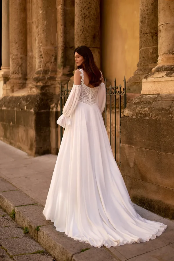 Dos et traîne d'une robe de mariée droite en mousseline à manches longues bouffantes