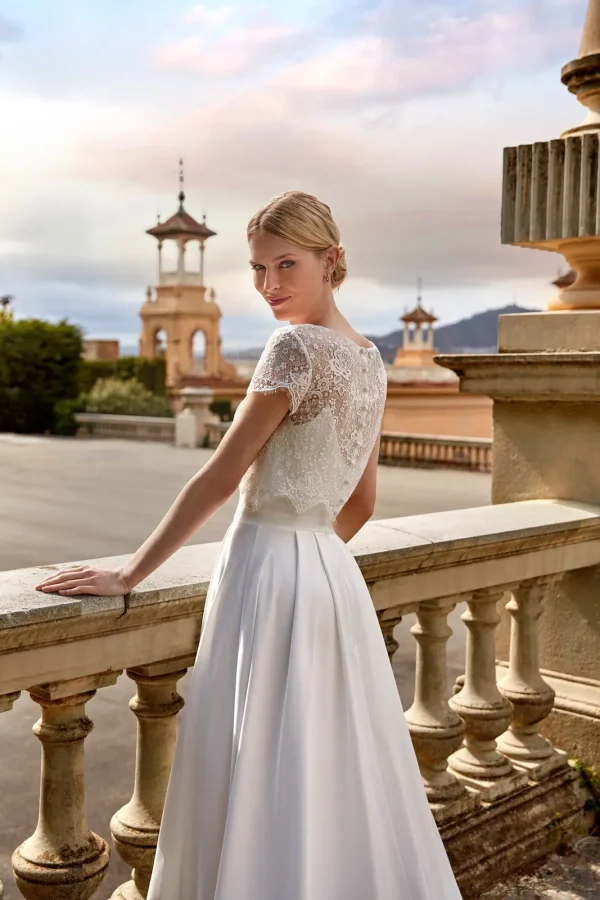 Dos du top en dentelle à manches courtes porté sur une robe de mariée en satin