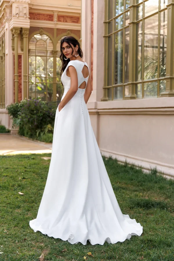 Dos ajouré boutonné et traîne d'une robe de mariée droite en satin