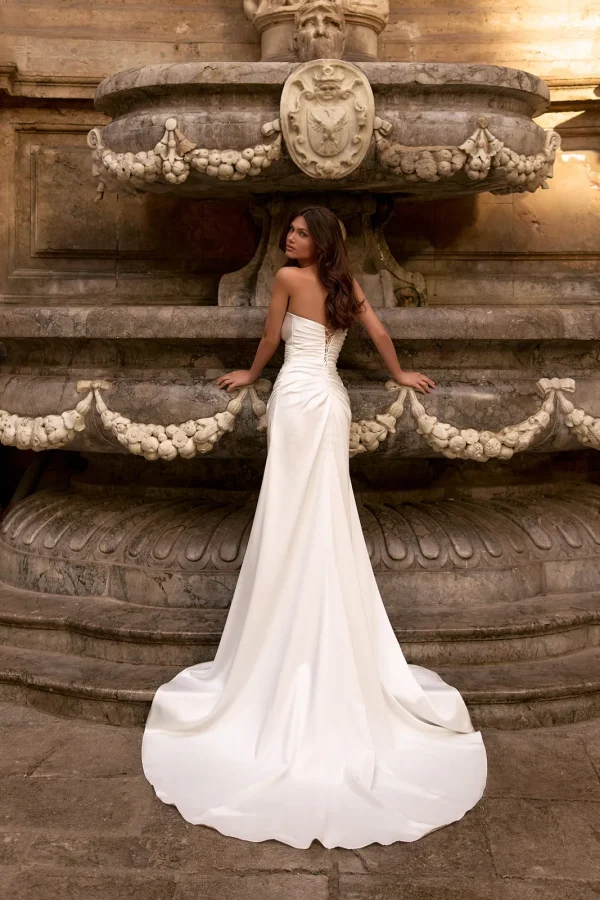 Dos et longue traîne d'une robe de mariée fourreau en satin bustier
