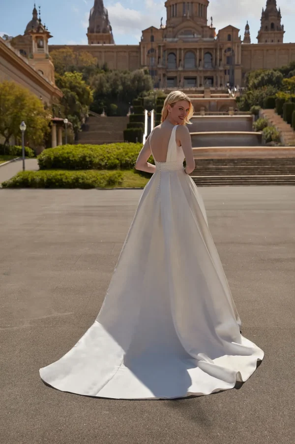Dos nu en V et longue traîne d'une robe de mariée princesse en mikado
