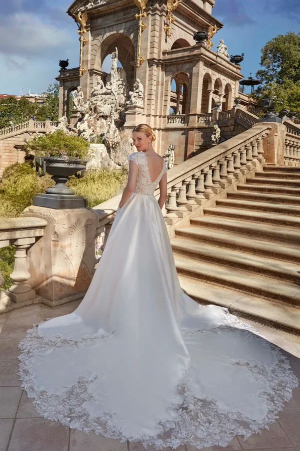 Dos en V et longue traîne bordée de dentelle d'une robe de mariée princesse en mikado
