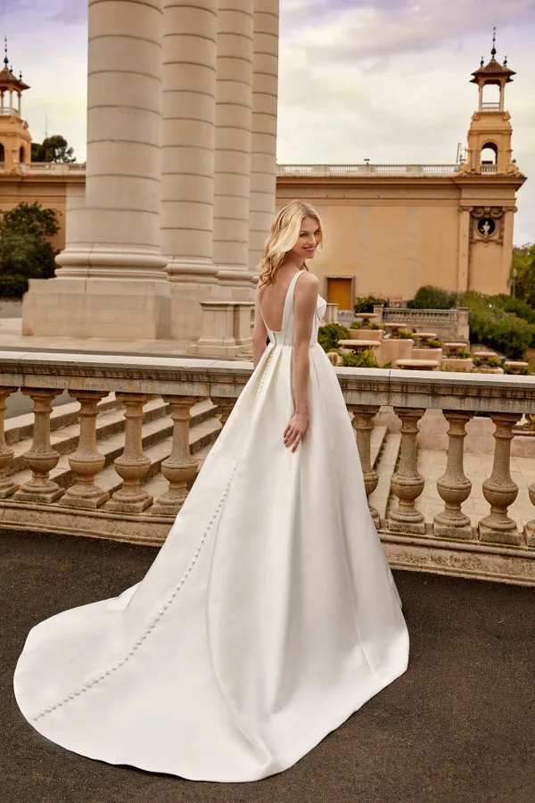 Dos nu et traîne boutonnée d'une robe de mariée princesse en mikado