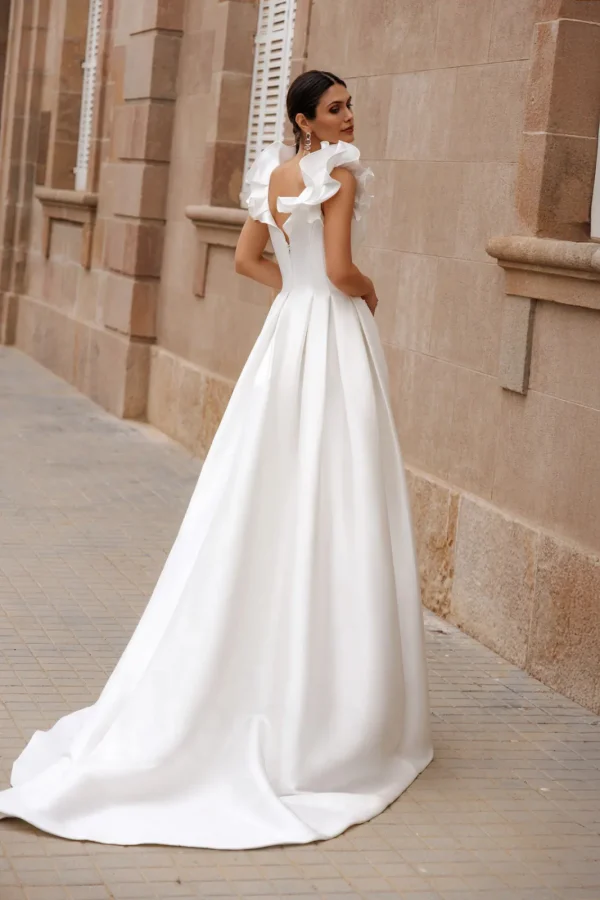 Dos nu et traîne d'une robe de mariée princesse en mikado à volants