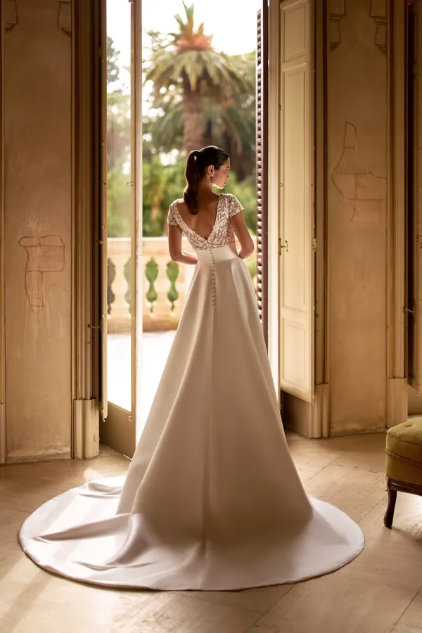 Dos en V et longue traîne d'une robe de mariée princesse en mikado