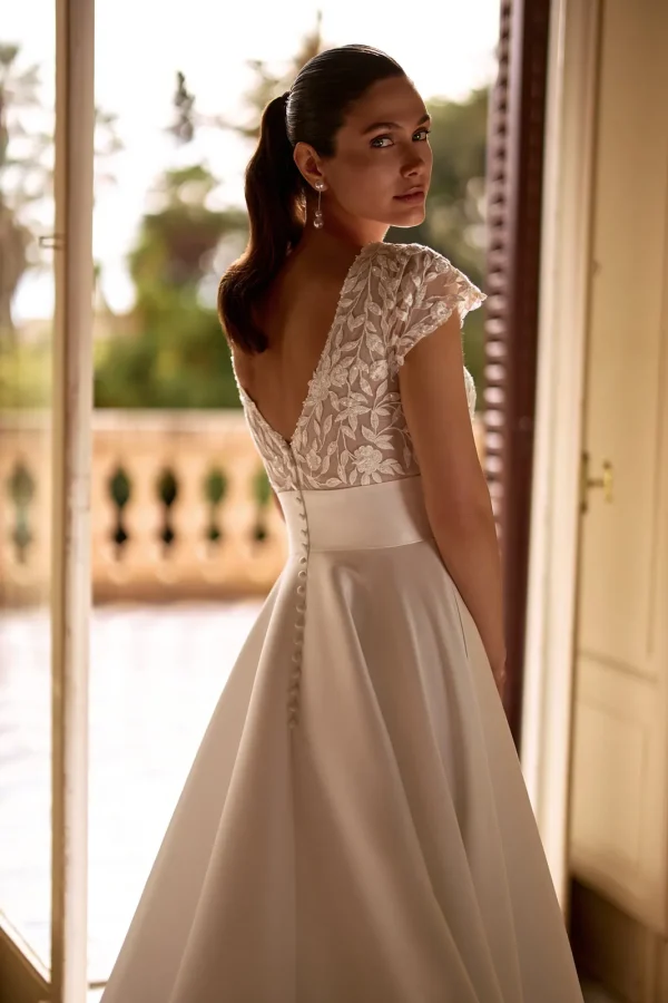 Dos en V en dentelle et boutons d'une robe de mariée princesse en mikado