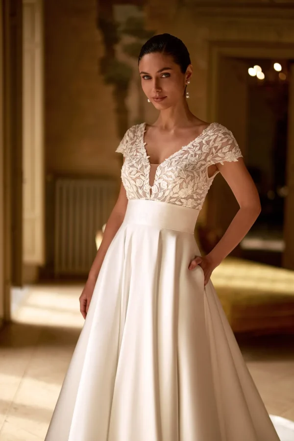 Corsage en dentelle à mancherons et ceinture en mikado d'une robe de mariée princesse