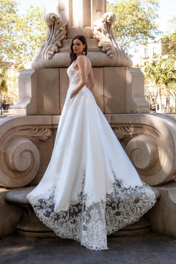 Longue traîne bordée de dentelle d'une robe de mariée princesse en satin