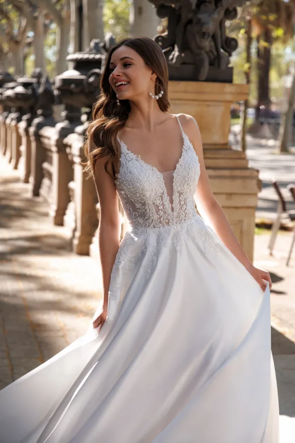 Corsage en dentelle transparente et décolleté plongeant d'une robe de mariée en satin