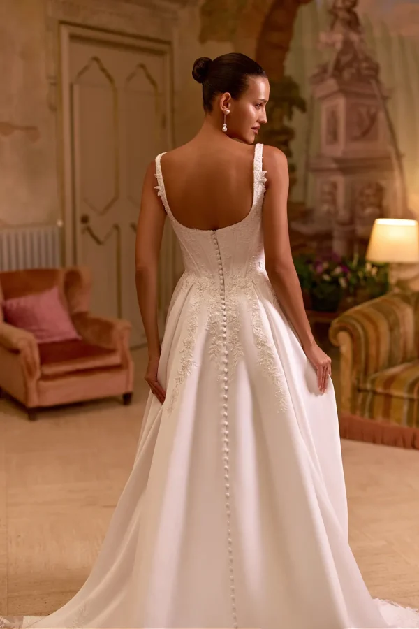 Dos décolleté et rangée de boutons d'une robe de mariée princesse en satin