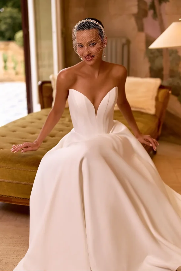 Mariée assise en robe de mariée princesse en satin à bustier cœur