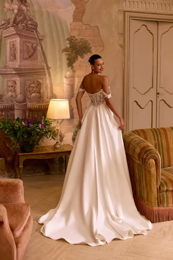 Dos boutonné et traîne d'une robe de mariée princesse en satin à épaules dénudées