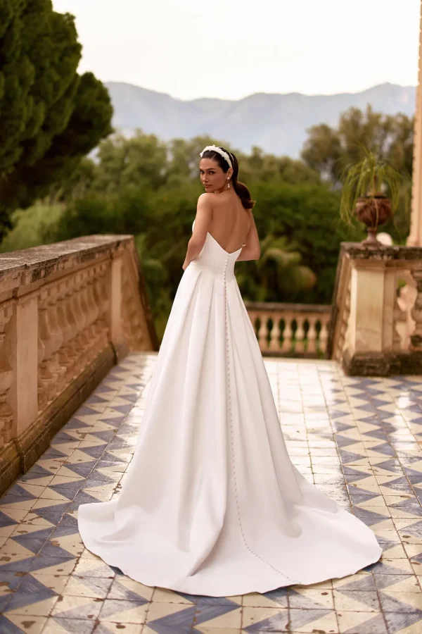 Dos nu boutonné et traîne d'une robe de mariée princesse en satin