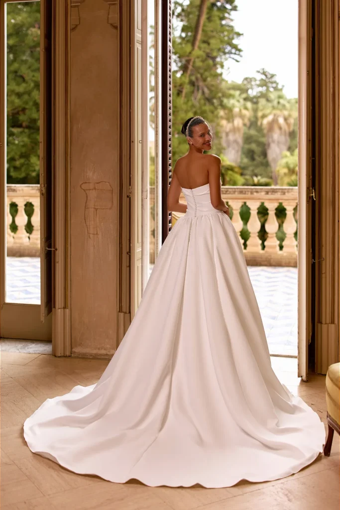 Dos boutonné et longue traîne d'une robe de mariée princesse en satin
