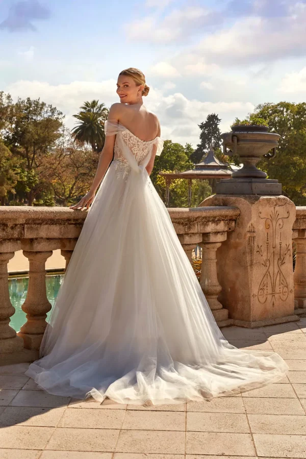 Dos en dentelle et traîne en tulle d'une robe de mariée princesse à épaules dénudées