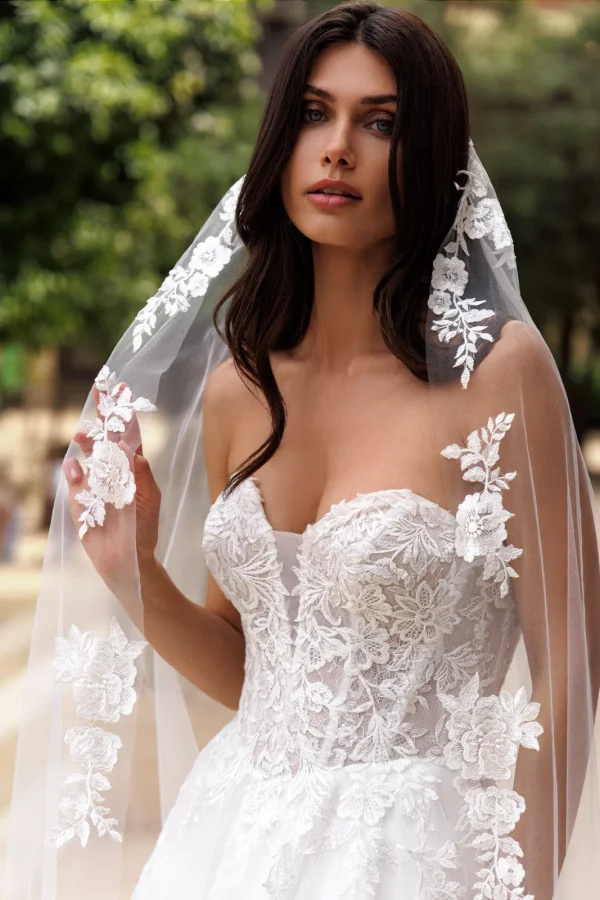 Voile 003 brodé porté sur le bustier en dentelle d'une robe de mariée princesse