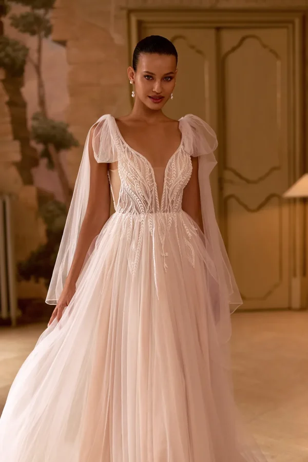 Nœuds en tulle aux épaules et corsage brodé d'une robe de mariée princesse nude