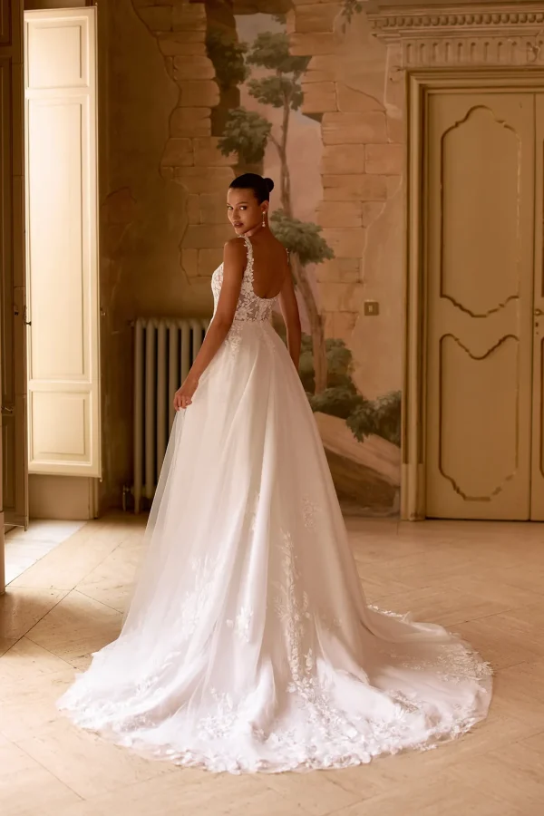Dos nu arrondi et traîne en dentelle d'une robe de mariée princesse en tulle